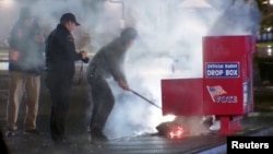 A still image from a video shows first responders pulling out the burning contents of a ballot box after it was set on fire in Vancouver, Washington, on Oct. 28, 2024. (Evan Bell/ABC Affiliate KATU via Reuters)