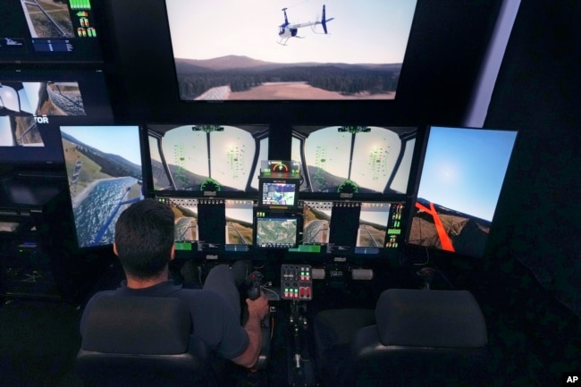 Joao Magioni, Chief Flight Officer of Rotor Technologies, flies a simulated unmanned semi-autonomous helicopter from the company's remote operations center, Monday, Nov. 11, 2024, in Nashua, N.H. (AP Photo/Charles Krupa)