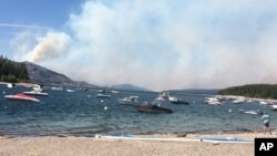 Smoke fills the sky in a view north toward Yellowstone National Park from Leeks Marina in Moose, Wyo., Aug. 23, 2016.