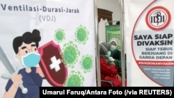 Seorang tenaga kesehatan menerima suntikan dosis kedua vaksin COVID-19 di sebuah rumah sakit di Sidoarjo, Jawa Timur, 29 Januari 2021. (Foto: Umarul Faruq/Antara Foto via Reuters)