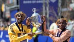 Sisay Lemma, of Ethiopia, left, winner of the men's division of the Boston Marathon, and Hellen Obiri, of Kenya, right, winner of the women's division of the race, hold the trophy on the finish line of the Boston Marathon, on April 15, 2024, in Boston.