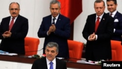 Turkey's President Abdullah Gul (C) is applauded by Prime Minister Tayyip Erdogan (R) and his ministers as he arrives to address the Turkish Parliament during a debate marking the reconvene of the parliament after a summer recess in Ankara, Oct. 1, 2013.