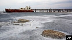 FILE - An abandoned ship is stuck in solidified salt at Lake Urmia, northwestern Iran. Once one of the biggest saltwater lakes on Earth, Urmia has been decimated by climate change, irrigation use and damming of nearby rivers.