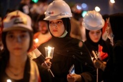 Iraqi women light candles for slain anti-government protesters during ongoing protests in Basra, Iraq, Nov. 29, 2019.