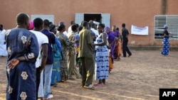 People wait in line to cast their ballots in a polling station in Ouagadougou during Burkina Faso's legislative and municipal elections, December 2, 2012. 