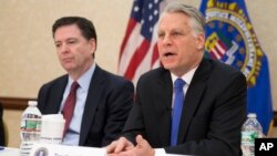 FBI Director James Comey, left, joins Timothy Roemer, a 9/11 Review Commission member and former congressman, at a news conference at FBI headquarters in Washington, March 25, 2015.