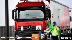 Ferry terminal workers from the Brexit info-team give a flyer to a truck driver to review that cargo can be transported quickly via Dutch ports after the Brexit, in Vlaardingen, Netherlands, March 13, 2019.