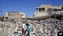 This citizen journalism image provided by Shaam News Network SNN, taken on Monday, Sept. 3, 2012, purports to show civilians walking among the rubble of buildings damaged by airstrikes in Azaz, on the outskirts of Aleppo, Syria. Syria's information minist