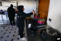 FILE—Mervat Reslan, right, cooks food for Iftar during the Muslim holy month of Ramadan at an abandoned hotel in Marwanieh, Lebanon, on March 15, 2024.