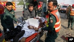 Para petugas mengangkut korban dalam ledakan bom di Lahore, Pakistan, Senin (24/7). 