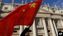 FILE - A pilgrim waves a Chinese flag during Pope Francis weekly general audience in St. Peter square at the Vatican, Nov. 22, 2017.