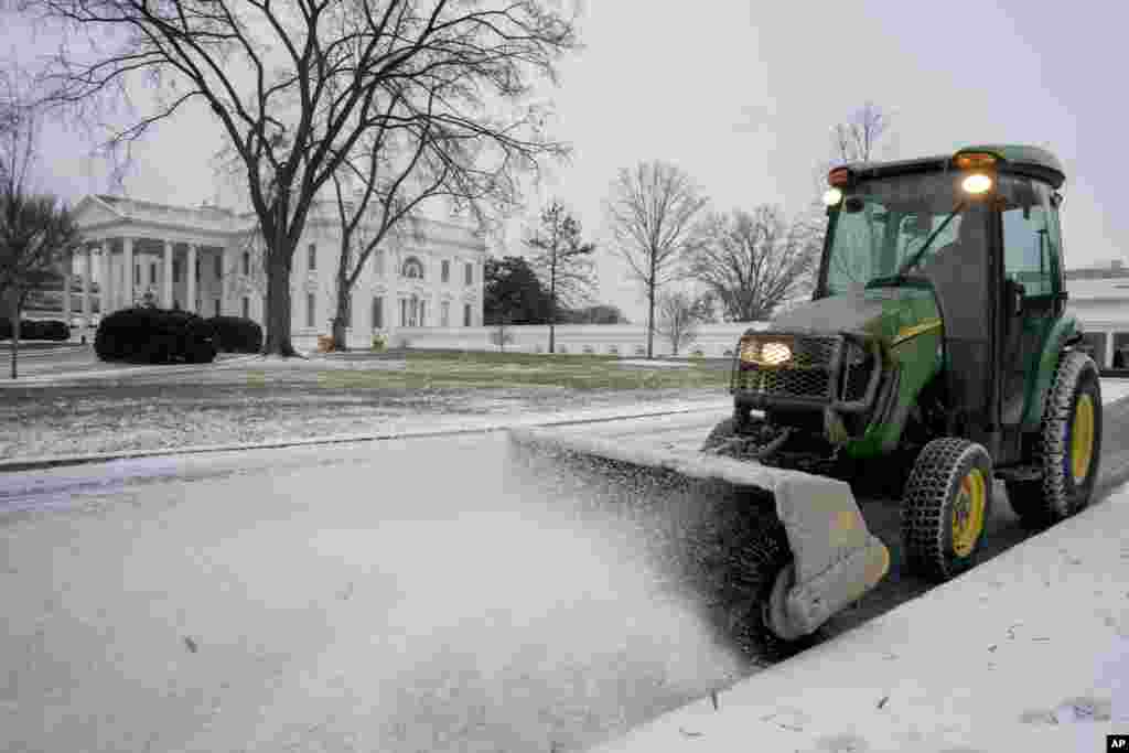 Un travailleur du Service des parcs nationaux déblaie la neige du côté nord de la Maison-Blanche, le jeudi 4 janvier 2018, à Washington.