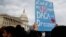 FILE - A woman holds up a sign outside the Capitol in support of the Deferred Action for Childhood Arrivals program, Dec. 5, 2017.