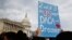 A woman holds up a sign outside the Capitol in support of the Deferred Action for Childhood Arrivals (DACA) program, Dec. 5, 2017, on Capitol Hill in Washington.
