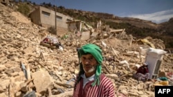 Seorang warga tampak berdiri di antara reruntuhan bangunan di desa Douzrou, provinsi al-Haouz, Maroko, pada 12 September 2023. Wilayah tersebut hancur dilanda gempa pada 8 September lalu. (Foto: AFP/Fadel Senna)