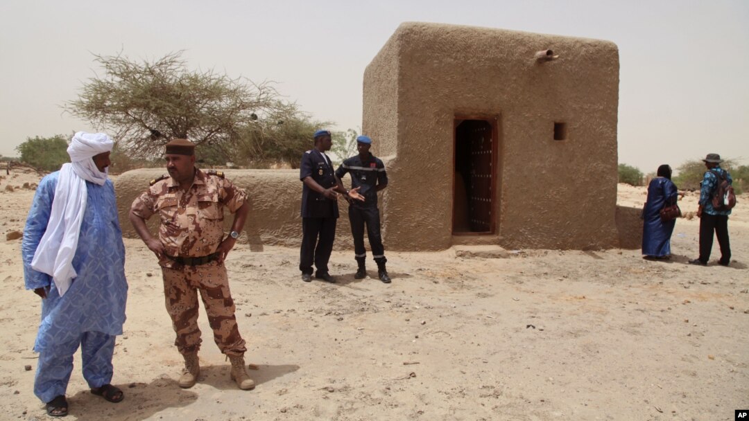 People attending a ceremony stand near a mausoleum that was restored in Timbuktu, Mali, July 18, 2015. 