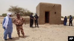 People attending a ceremony stand near a mausoleum that was restored in Timbuktu, Mali, July 18, 2015. 