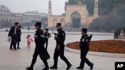 In this Nov. 4, 2017 photo, Uighur security personnel patrol near the Id Kah Mosque in Kashgar in western China's Xinjiang region. (AP Photo/Ng Han Guan)