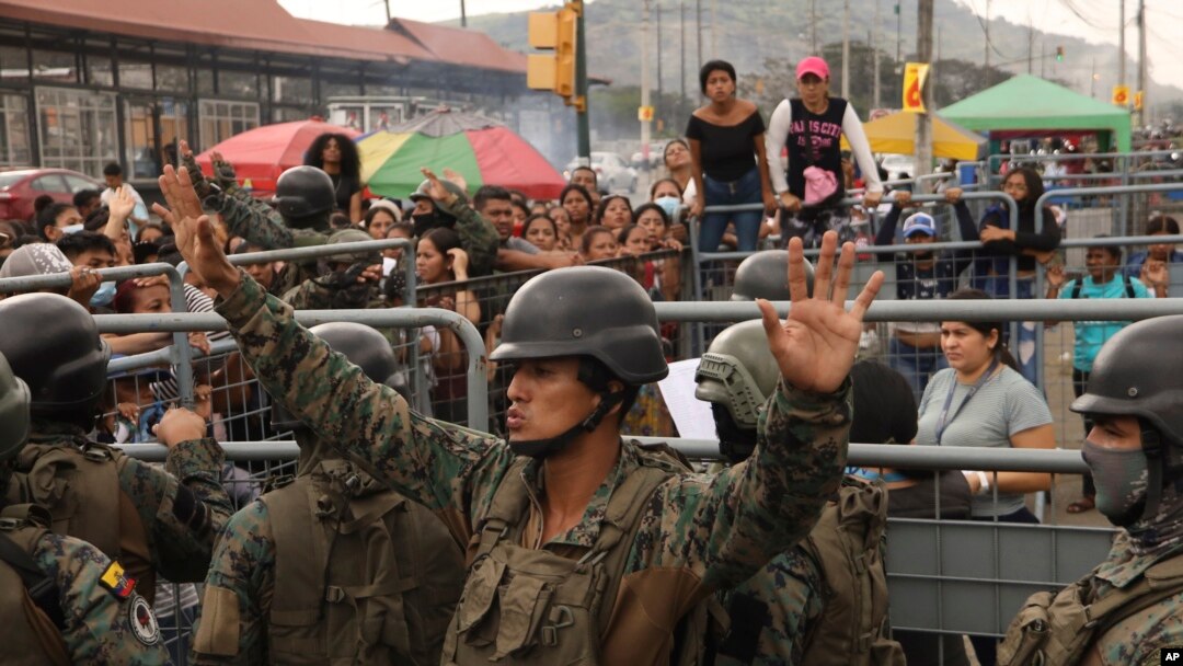 ARCHIVO - Un soldado pide calma a los amigos y familiares de los reclusos que buscan información tras los mortales enfrentamientos en la Penitenciaría del Litoral, en Guayaquil, Ecuador, el 25 de julio de 2023.