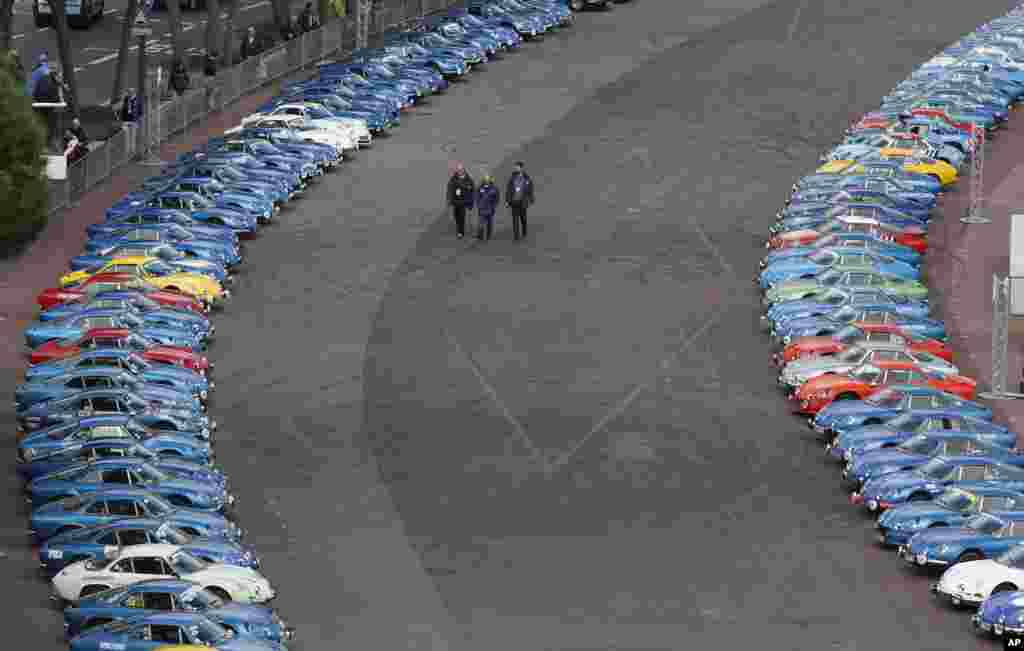 People walk between old Alpine Renault Berlinettes during the official presentation of the new Alpine Renault Vision auto by chairman and CEO of Renault Carlos Ghosn in Monaco.
