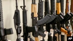 FILE - Various models of semi-automatic rifles are displayed at a store in Pennsylvania, March 1, 2018.