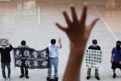 Protesters gesture with five fingers, signifying the "Five demands - not one less" in a shopping mall during a protest against China's national security legislation for the city, in Hong Kong, May 29, 2020.