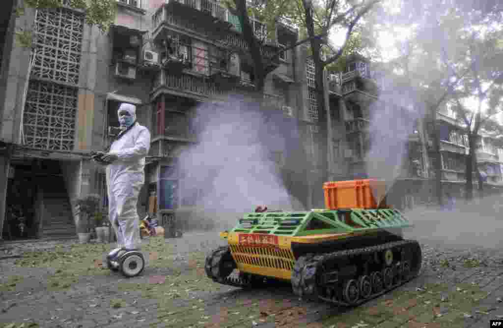 A volunteer operates a remote-controlled robot to disinfect a neighborhood amid the COVID-19 outbreak in Wuhan, in China&#39;s central Hubei province.