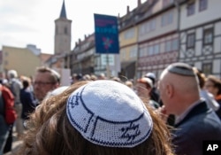 People of different faiths wear Jewish skullcaps during a demonstration against anti-Semitism in Germany, in Erfurt, Germany, April 25, 2018.