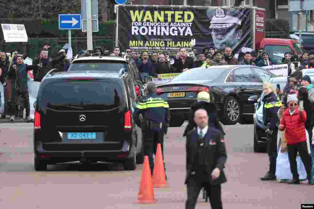 Myanmar&#39;s leader Aung San Suu Kyi leaves in a car that passes by protesters after attending a hearing in a case filed by The Gambia accusing Myanmar of genocide against the minority Muslim Rohingya population, at the International Court of Justice (ICJ) in The Hague, Netherlands.