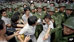 天安门民主抗议，解放军试图将这个女学生拉出抗议集会。