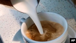 In this photo taken Friday, Sept. 22, 2017, a barista pours steamed milk in a coffee at a cafe in Los Angeles. In a long-running court case playing out in a Los Angeles courtroom, a nonprofit has been presenting evidence to show that coffee companies should post ominous warning labels about a cancer-causing chemical in every cup. (AP Photo/Richard Vogel)