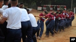 FILE - Indian army women recruits compete with men in a tug-of-war as part of their training before they are inducted as the first women soldiers below officer rank, during a media visit in Bengaluru, India.