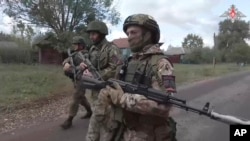 FILE - In this photo taken from video released by the Russian Defense Ministry on Oct. 24, 2024, Russian soldiers patrol in a village on Russia's border with Ukraine. (Russian Defense Ministry Press Service photo via AP)