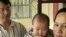 Taiwanese security guard Huang Chin-tsai, 44, looks at his his wife, Vu Thi Minh, 30, from Vietnam and their six-month-old daughter in their home, in Wanli, 30 miles north of Taipei, Taiwan, March 1, 2003.