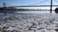 A layer of ice is broken into pieces floating along the banks of the Hudson River at the Palisades Interstate Park with the George Washington Bridge in the background, Jan. 2, 2018, in Fort Lee, New Jersey.