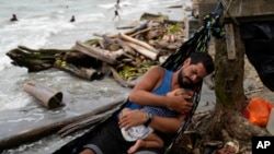 ARCHIVO - Jackson Vargas, migrante venezolano, sostiene a su bebé en sus brazos en Necoclí, Colombia, el 14 de octubre de 2024. Curazao reportó el arresto de 22 venezolanos que intentaban ingresar a su territorio sin la documentación necesaria. 