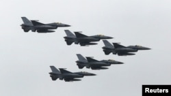 FILE - Taiwan Air Force's F-16 fighter jets fly during a military exercise at an army base in Hsinchu, Taiwan, July 4, 2015. Chinese Foreign Ministry spokesman says Washington's plan to sell Taipei $330 million of spare parts for the F-16 fighter jet, the C-130 cargo plane and other military aircraft violates international laws.