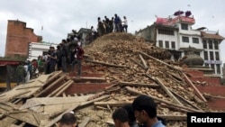People survey a site damaged by an earthquake, in Kathmandu, Nepal, April 25, 2015.