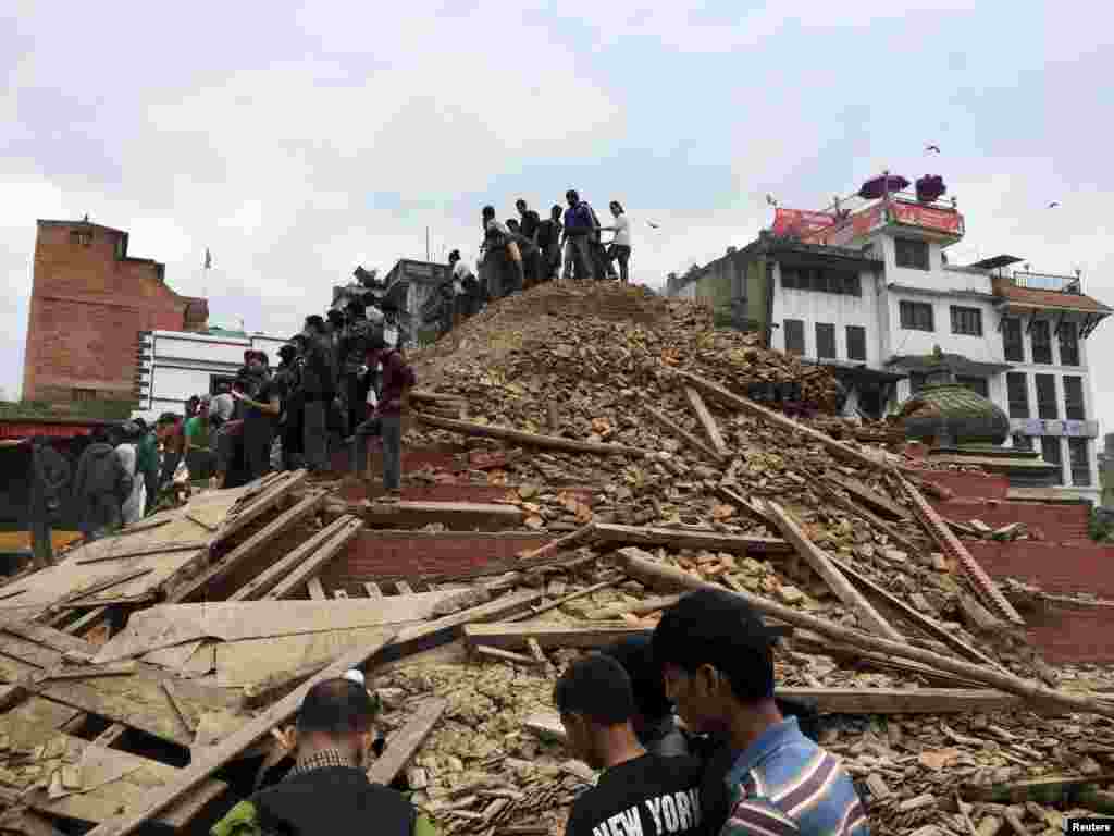 People survey a site damaged by an earthquake, in Kathmandu, Nepal, April 25, 2015.