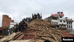 People survey a site damaged by an earthquake, in Kathmandu, Nepal, April 25, 2015.