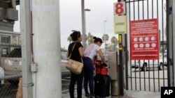 FILE - Josseline Garcia, 20, and Jennifer Garcia, 24, sisters from Guatemala seeking asylum, cross a bridge to a port of entry in to the United States from Matamoros, Mexico, June 20, 2018, in Brownsville, Texas. 