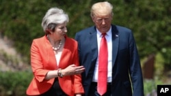 British Prime Minister Theresa May walks with President Donald Trump prior to a joint press conference at Chequers, in Buckinghamshire, England, July 13, 2018.