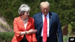 British Prime Minister Theresa May walks with President Donald Trump prior to a joint press conference at Chequers, in Buckinghamshire, England, July 13, 2018.