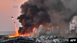 Un hélicoptère éteint un incendie sur les lieux d'une explosion dans le port de Beyrouth, la capitale du Liban, le 4 août 2020.