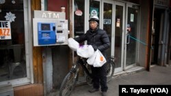 Một người Trung Quốc giao hàng bằng xe đạp điện. (ảnh của R. Taylor/VOA tháng 2/2018)