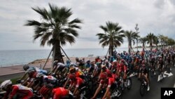 The pack rides along the beach of the Promenade des Anglais during the first stage of the Tour de France, with start and finish in Nice, southern France, Aug. 29, 2020.