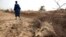 Un éleveur s'éloigne d'une carcasse d'une de ses vaches mortes de faim, dans la périphérie du village de Dikka, dans la région de Matam au nord-est du Sénégal, le 1er mai 2012.