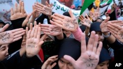 Estudantes iranianas mostram as mãos com slogans pró-governo e um slogan anti-israelita que diz em farsi: “Morte a Israel”, durante um comício em frente à antiga Embaixada dos EUA em Teerão, Irão, em 4 de novembro de 2023