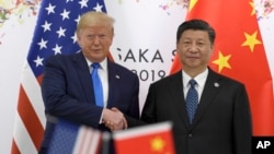 时任美国总统特朗普与中国国家主席习近平2019年6月在大阪召开的G20峰会上握手。（资料照片，2019年6月29日）