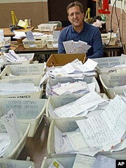 Pete Fontana, who oversees Operation Santa, amid the stacks of children's letters addressed to Santa Claus.